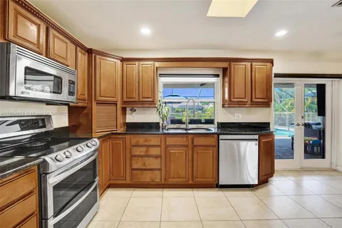 a kitchen with stainless steel appliances granite countertop a stove top oven a sink a counter space and cabinets