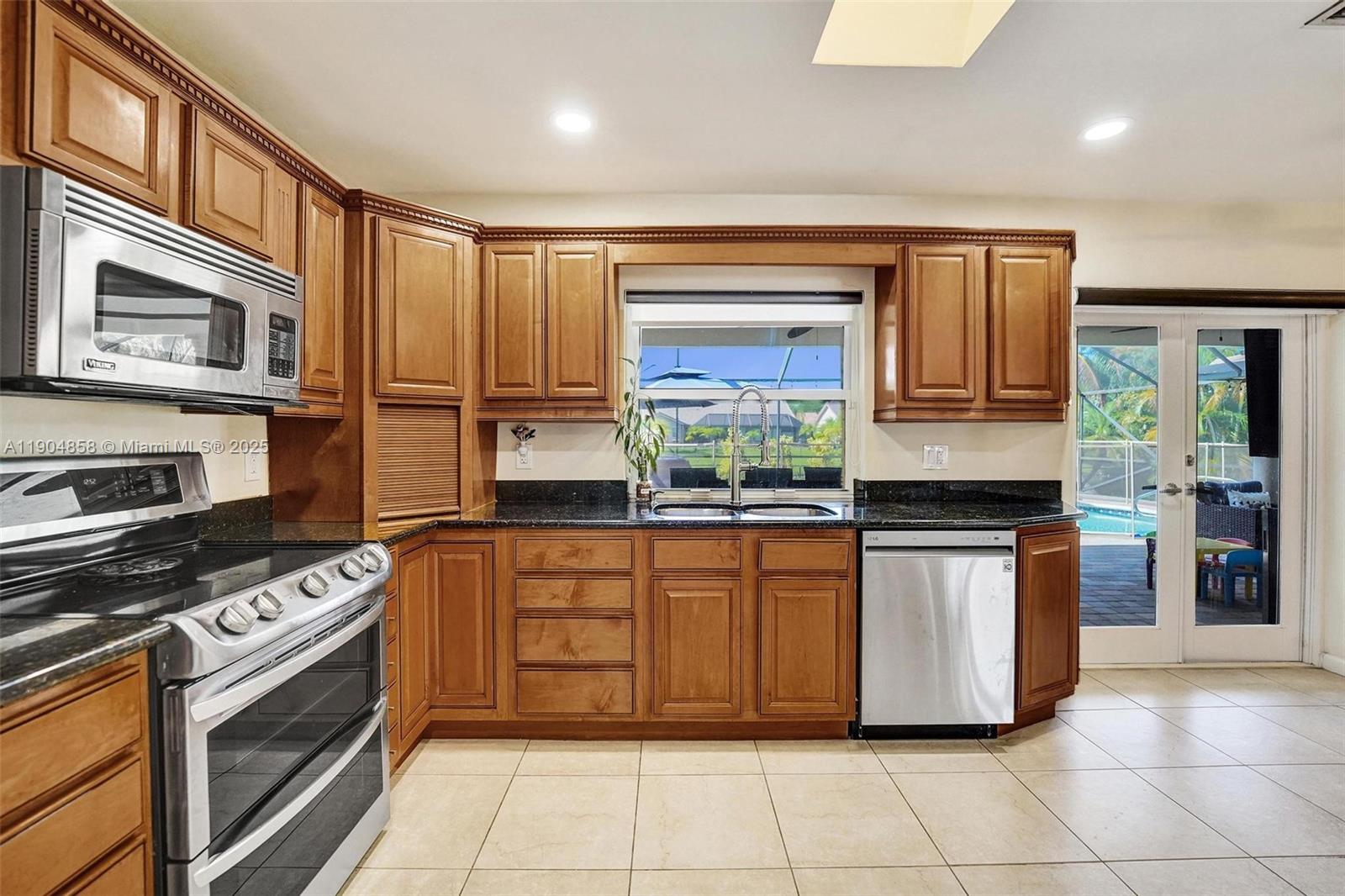 1501 Northwest 99th Avenue Plantation, FL 33322 - Photo 13 of 45 a kitchen with stainless steel appliances granite countertop a stove top oven a sink a counter space and cabinets