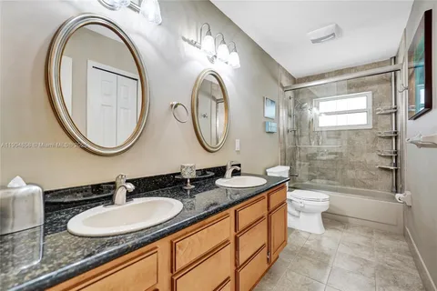 a bathroom with a double vanity sink double mirror and a toilet