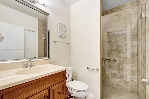 a bathroom with a sink toilet vanity and shower