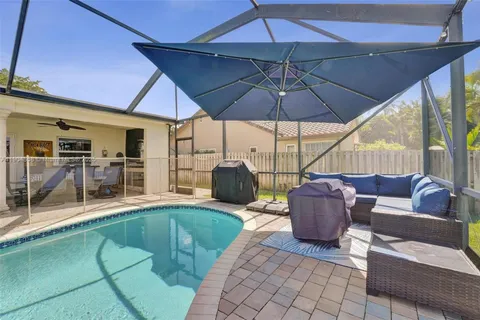 a view of a patio with couches chairs under an umbrella