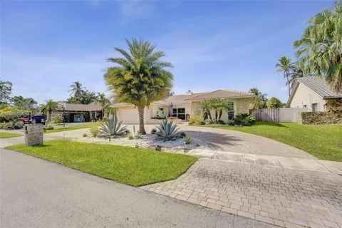 a front view of a house with garden and swimming pool