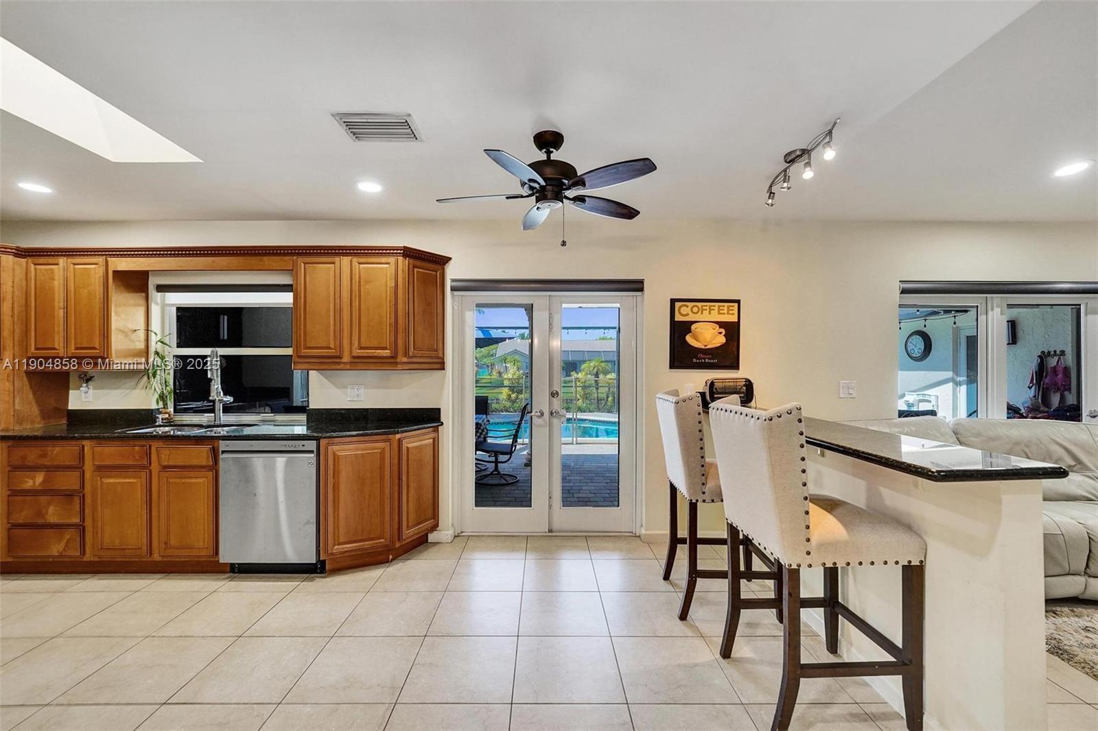 1501 Northwest 99th Avenue Plantation, FL 33322 - Photo 9 of 45 a kitchen with stainless steel appliances granite countertop a stove top oven a sink dishwasher a dining table and chairs with wooden floor