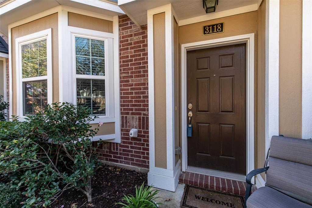 3118 Bedford Road Bedford, TX 76021 - Photo 2 of 29 Entryway featuring a paneled front door, white trim, brick accents, and a bay window