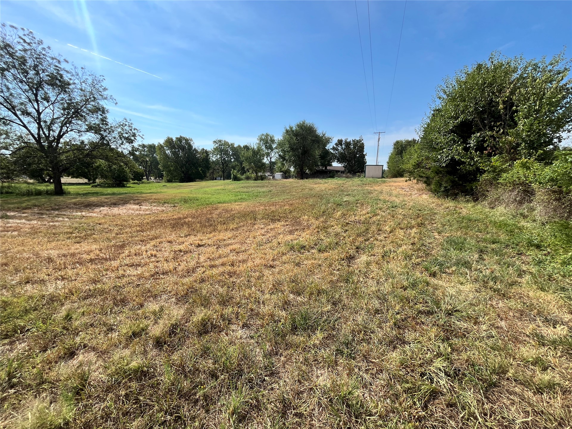 11131 215th Road Nowata, OK 74048 - Photo 38 of 47 From far NW corner of property looking back to the house. Expansive open field with scattered trees and clear skies