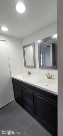 a bathroom with a double vanity sink and mirror