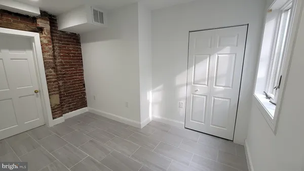an empty room with windows and closet