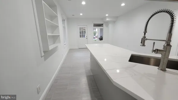a large white kitchen with sink a refrigerator and a stove