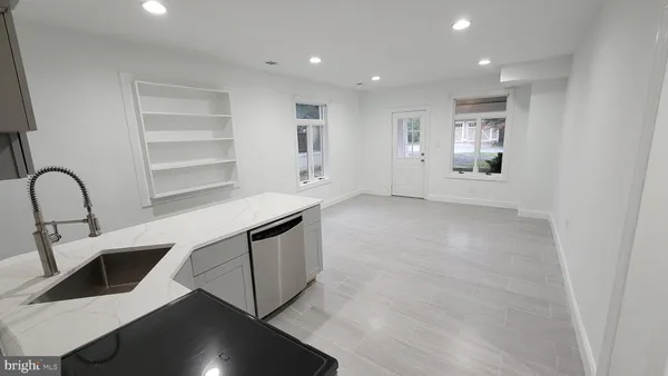 a kitchen with stainless steel appliances kitchen island granite countertop a refrigerator and a stove top oven