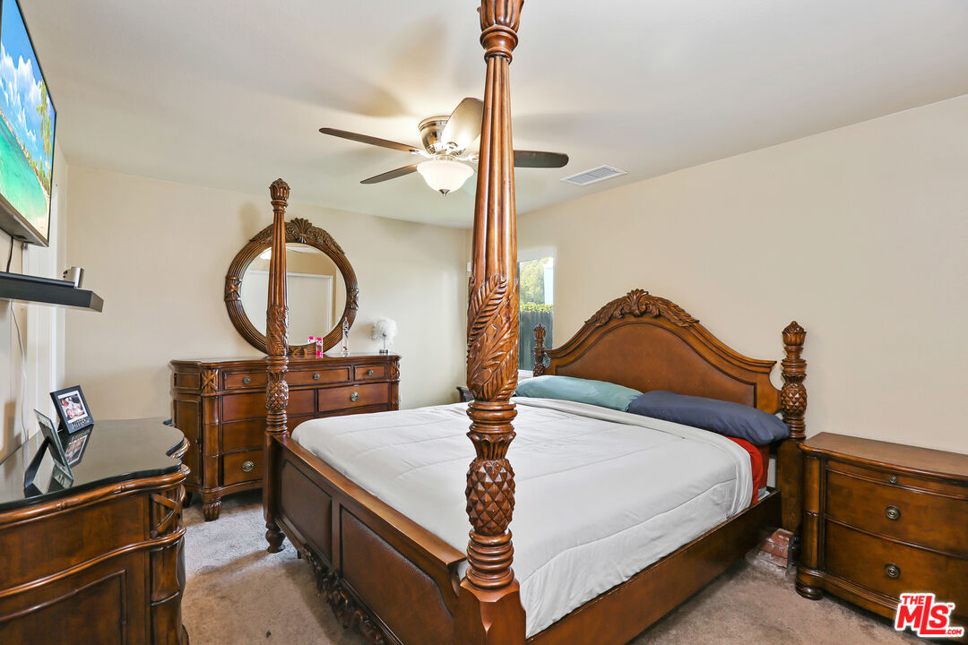 9225 Flax Place Riverside, CA 92503 - Photo 16 of 35 a bedroom with a bed a mirror and desk
