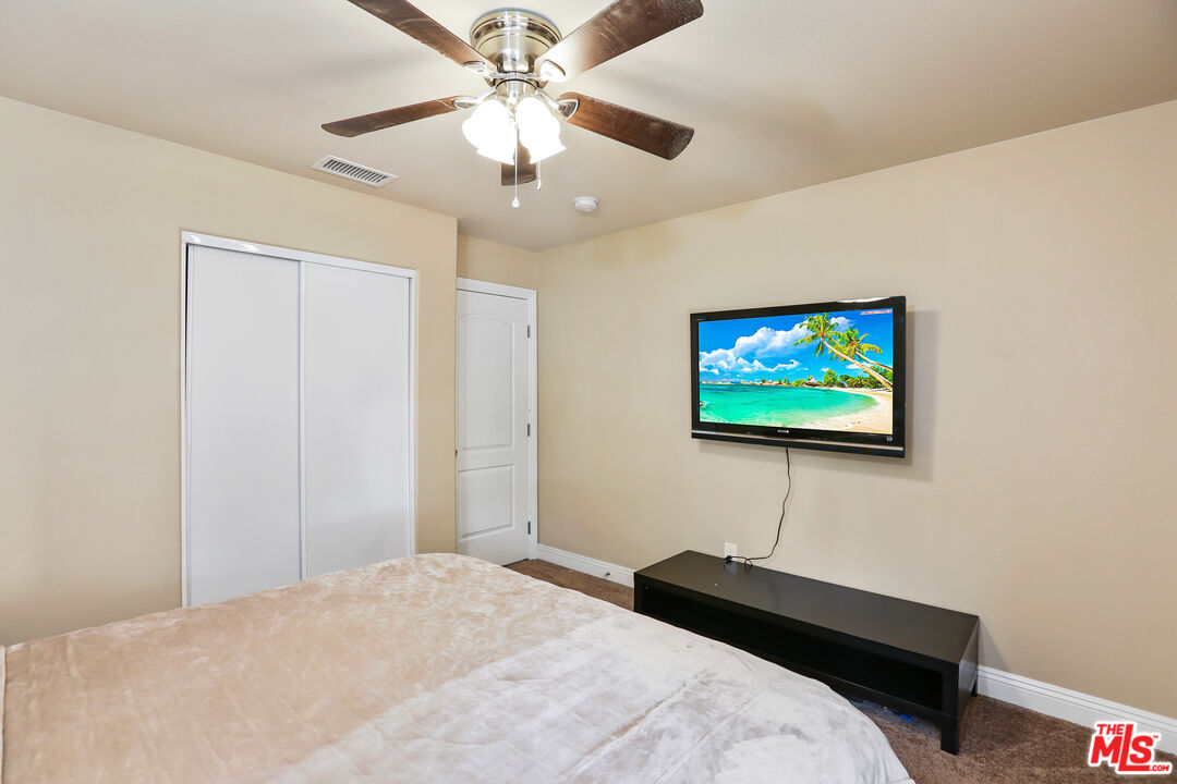 9225 Flax Place Riverside, CA 92503 - Photo 17 of 35 a bedroom with a bed and a chandelier