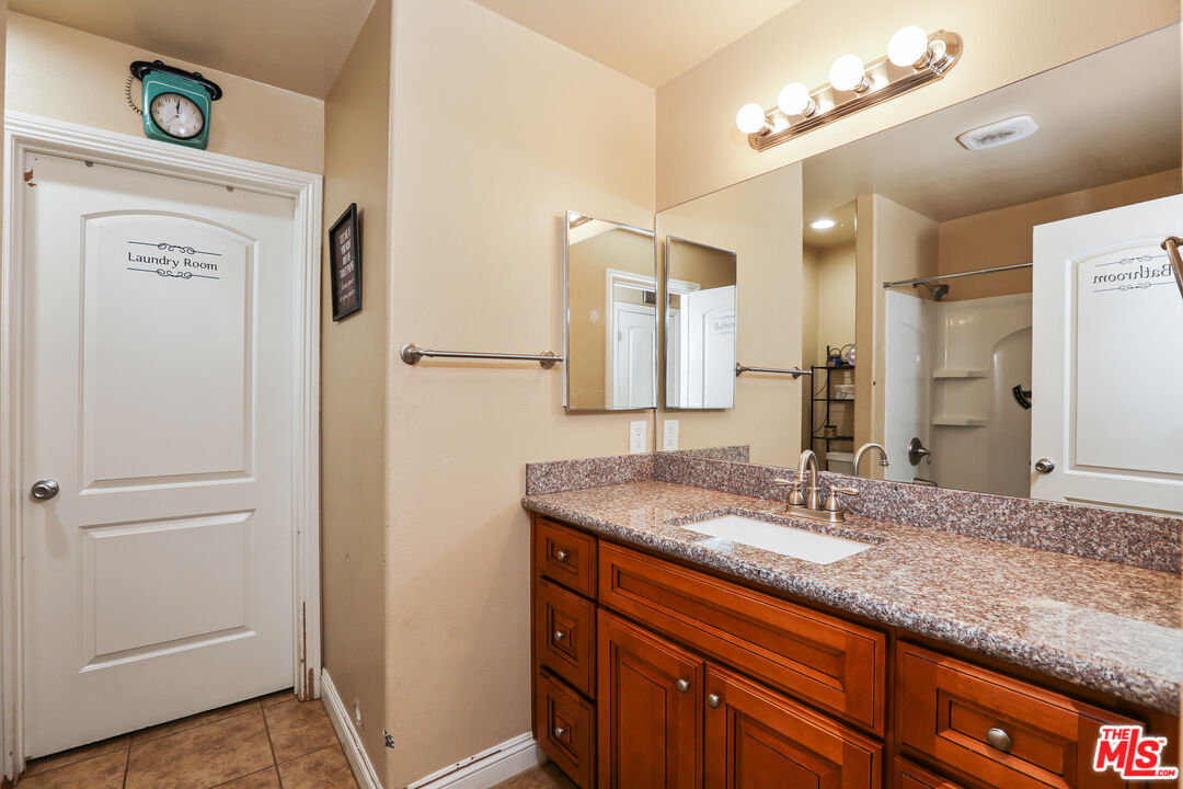 9225 Flax Place Riverside, CA 92503 - Photo 20 of 35 a bathroom with a granite countertop sink and a mirror
