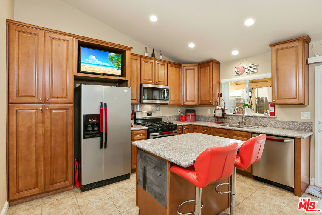 9225 Flax Place Riverside, CA 92503 - Photo 9 of 35 a kitchen with stainless steel appliances granite countertop a refrigerator a sink dishwasher a stove with wooden cabinets and floor