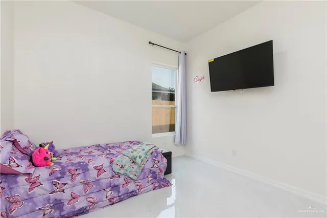 a bedroom with a bed and a flat screen tv