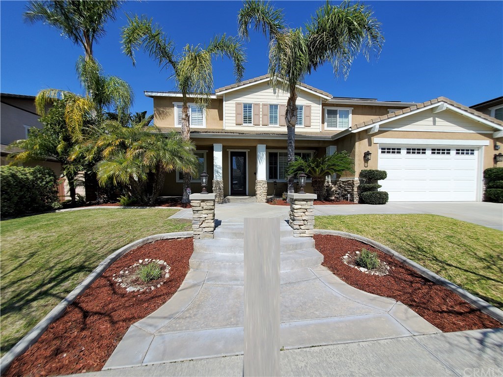 a view of a white house with a big yard and potted plants