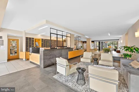 a living room with furniture and a view of kitchen