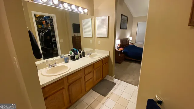 a en suite bathroom with a double vanity sink a mirror and a shower