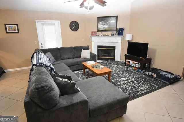 a living room with furniture a fireplace and a flat screen tv