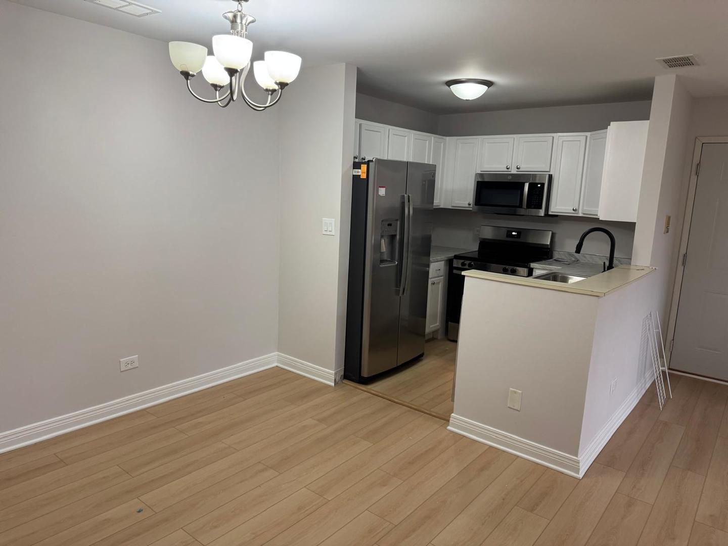 1935 North Hicks Road, Unit 106 Palatine, IL 60074 - Photo 16 of 16 a view of a kitchen with a sink wooden floor and a refrigerator