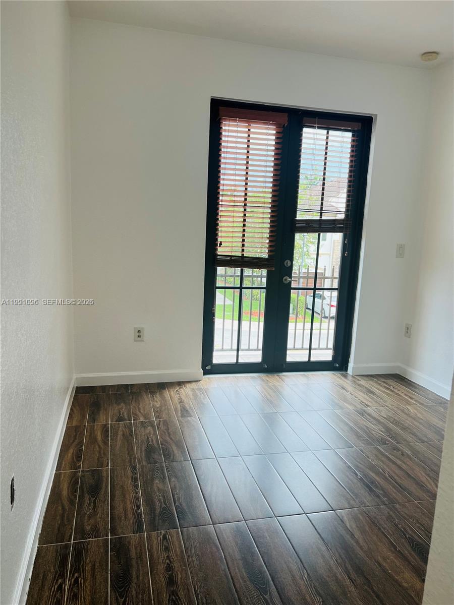11219 Southwest 234 Terrace, Unit 11219 Homestead, FL 33032 - Photo 15 of 16 an empty room with wooden floor and windows