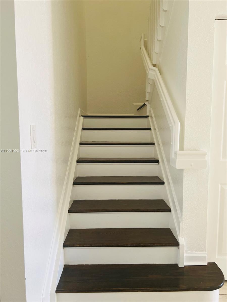 11219 Southwest 234 Terrace, Unit 11219 Homestead, FL 33032 - Photo 4 of 16 a view of staircase with white walls and a black white checkered floor