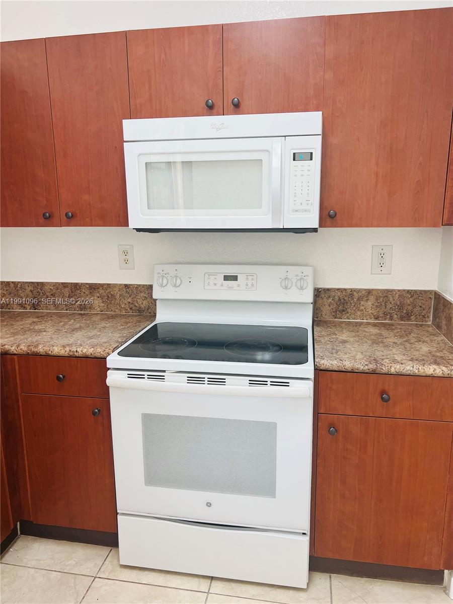 11219 Southwest 234 Terrace, Unit 11219 Homestead, FL 33032 - Photo 6 of 16 a stove top oven sitting inside of a kitchen
