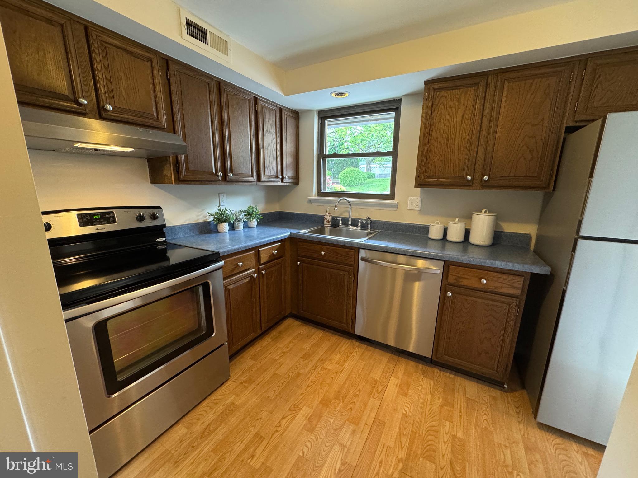 315 South Valley Forge Road, Unit 7 Devon, PA 19333 - Photo 3 of 26 a kitchen with stainless steel appliances a sink a stove a refrigerator cabinets and a window