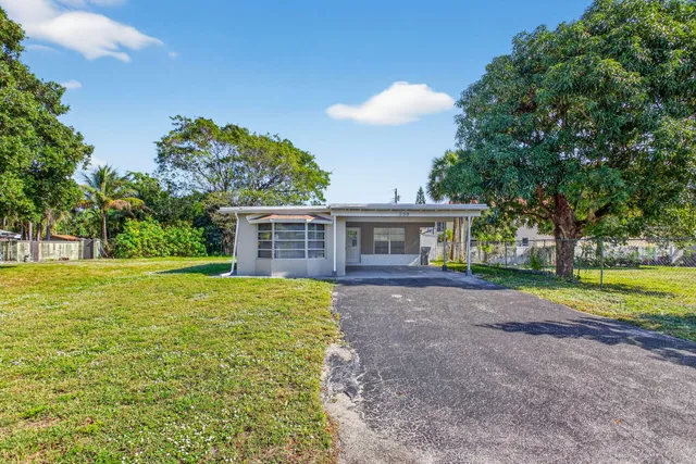 a view of a house with backyard and trees