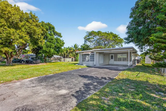 a view of a house with a yard and tree s