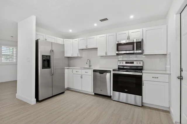 a kitchen with stainless steel appliances a refrigerator stove and microwave