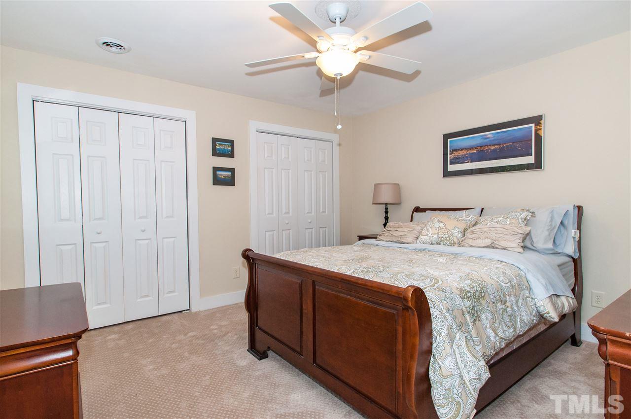 11905 Deer Run Raleigh, NC 27614 - Photo 15 of 25 a bedroom with a large bed and a chandelier