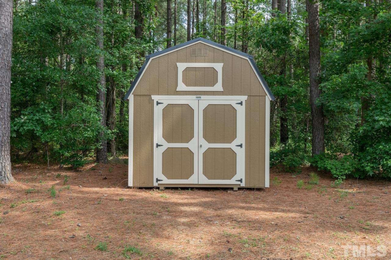 558 Fontana Drive Clayton, NC 27527 - Photo 39 of 41 a view of a wooden house with a yard and large trees
