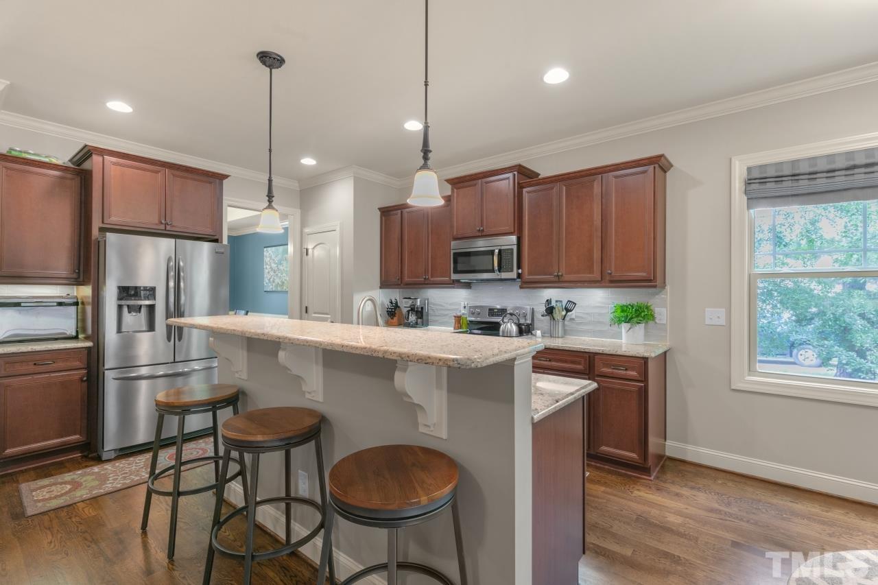 558 Fontana Drive Clayton, NC 27527 - Photo 6 of 41 a kitchen with kitchen island granite countertop wooden cabinets and a stainless steel appliances