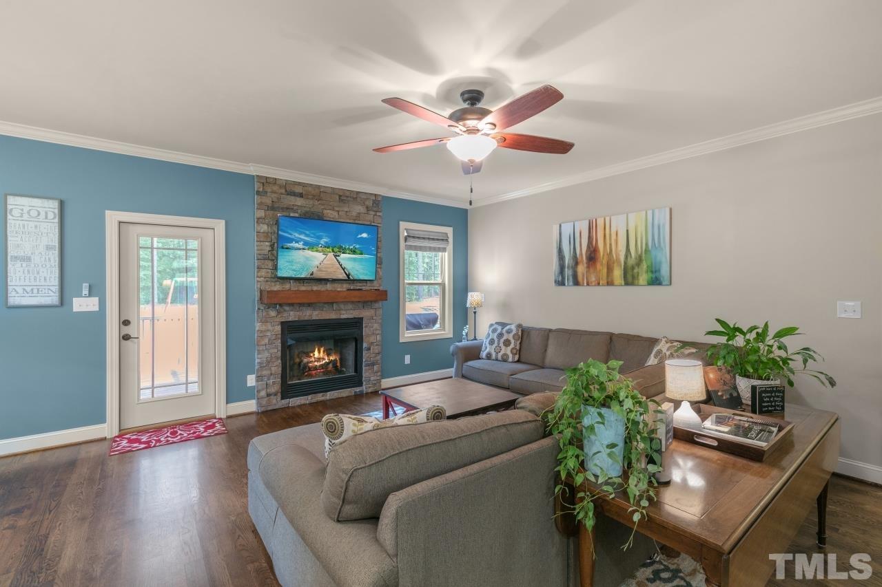 558 Fontana Drive Clayton, NC 27527 - Photo 8 of 41 a living room with furniture a fireplace and a potted plant