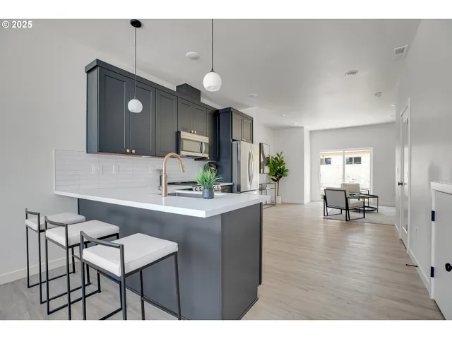 a kitchen with granite countertop a refrigerator stove top oven and sink