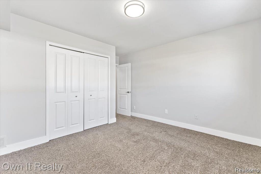 59314 Van Dyke Road Washington, MI 48094 - Photo 8 of 16 Unfurnished bedroom featuring carpet and a closet