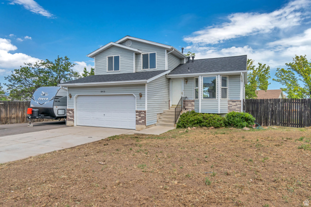 843 Deer Flat Road Tooele, UT 84074 - Photo 2 of 27 Gray two-story residence featuring light siding and stone veneer accents