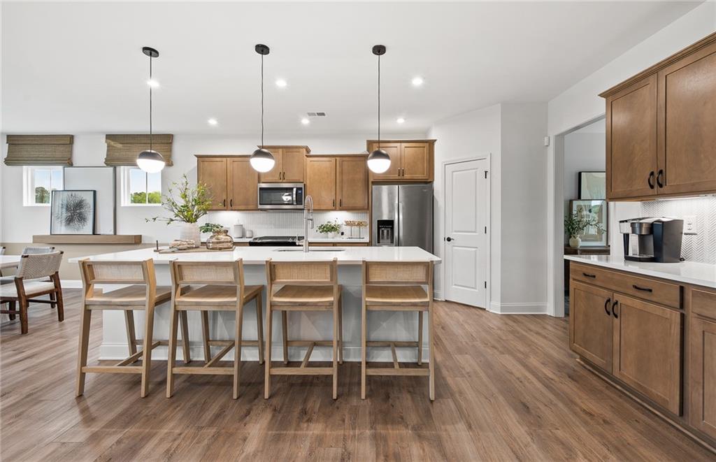 808 Tupelo Way Villa Rica, GA 30180 - Photo 11 of 48 a kitchen with stainless steel appliances kitchen island granite countertop a table chairs and a sink