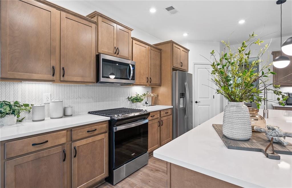 808 Tupelo Way Villa Rica, GA 30180 - Photo 15 of 48 a kitchen with stainless steel appliances kitchen island granite countertop a refrigerator a sink a stove and cabinets