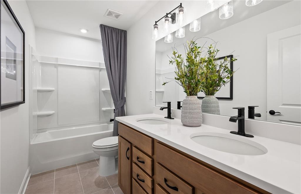 808 Tupelo Way Villa Rica, GA 30180 - Photo 39 of 48 a bathroom with a granite countertop sink a toilet and shower