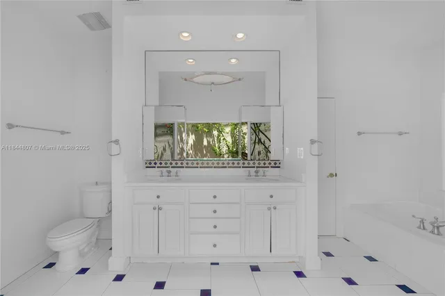 a bathroom with a sink tub double vanity and mirror