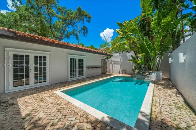 a view of a white house with a large tree