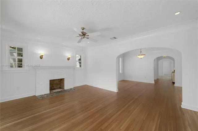 a view of empty room with wooden floor and fireplace