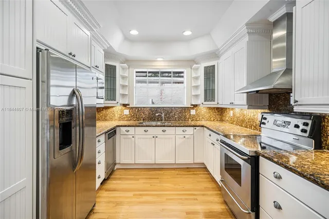 a kitchen with stainless steel appliances granite countertop a refrigerator and cabinets