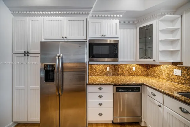 a kitchen with granite countertop white cabinets and white appliances
