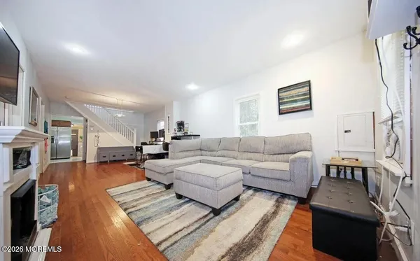 a living room with furniture and a wooden floor