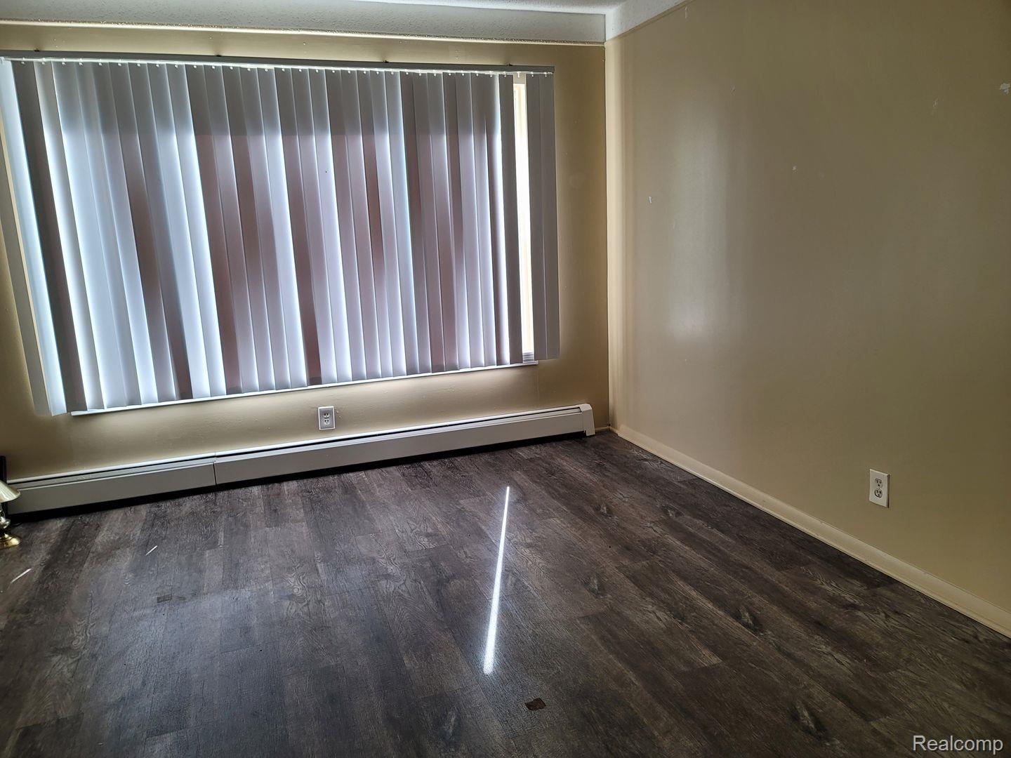 16470 East 9 Mile Road, Unit 104 Eastpointe, MI 48021 - Photo 14 of 14 Unfurnished room with a baseboard radiator and dark wood finished floors