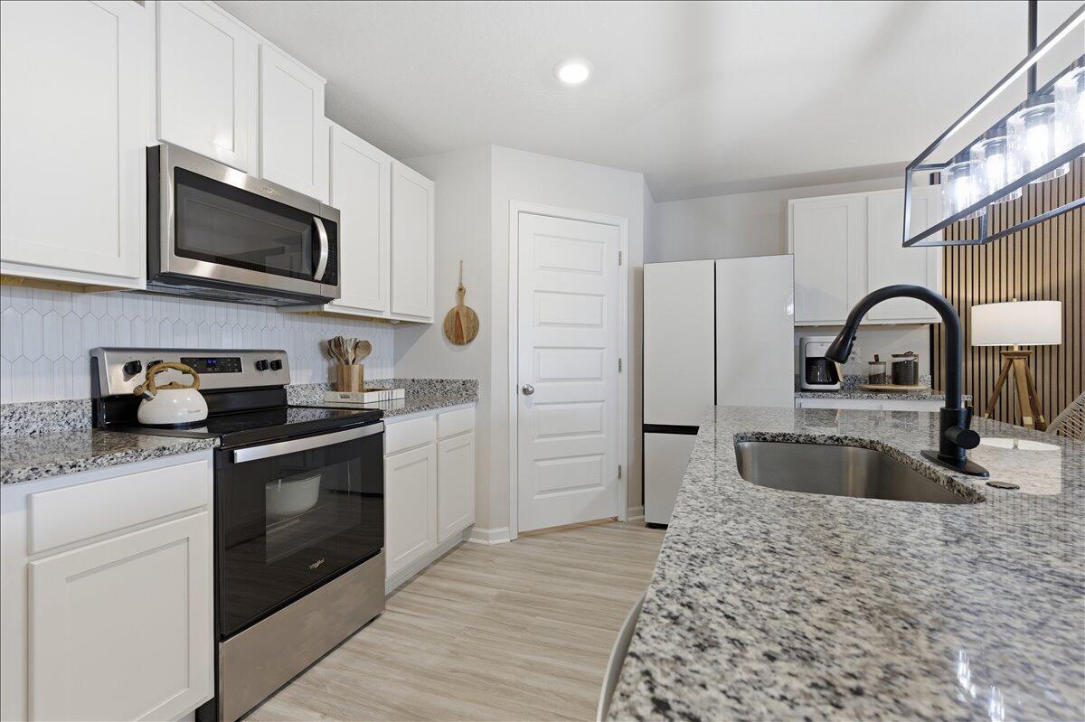943 Sandbar Loop Crestview, FL 32539 - Photo 18 of 59 a kitchen with a sink stove and refrigerator
