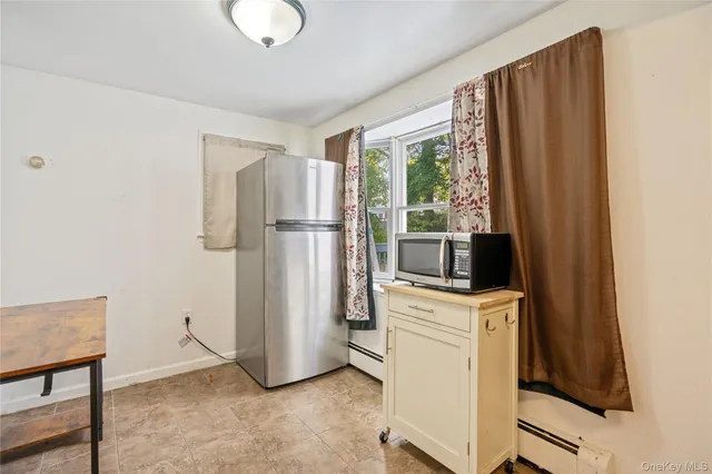 a view of kitchen with stainless steel appliances wooden floor and window