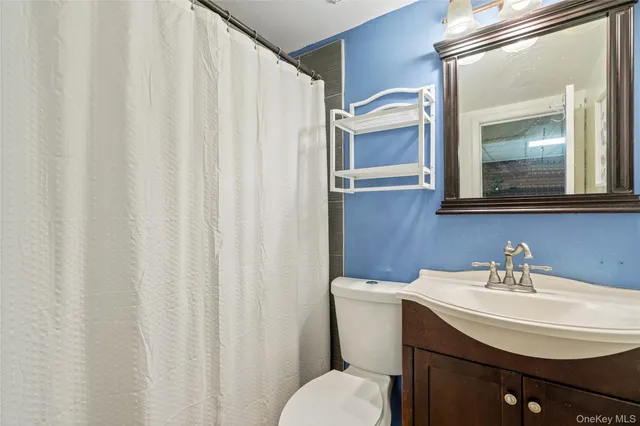 a bathroom with a sink a toilet and a mirror